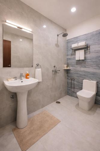 a bathroom with a sink and a toilet and a mirror at The Vedam Hotels - Ram Mandir Ayodhya A unit of RL Group of Hotels Ayodhya in Ayodhya