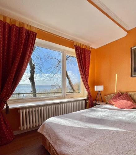 a bedroom with a bed and a large window at Exklusive Ferienwohnung Strohberg in Plön