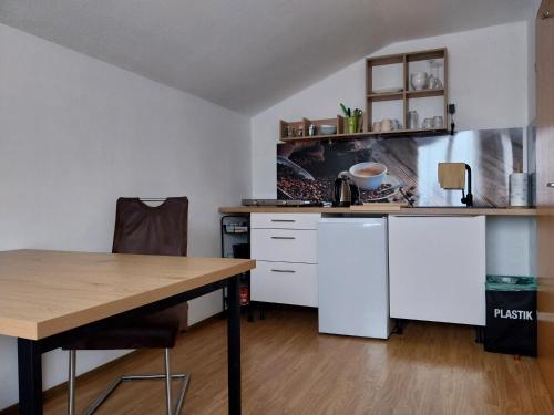 a kitchen with white cabinets and a wooden table at Haus Lorang in Pfronten