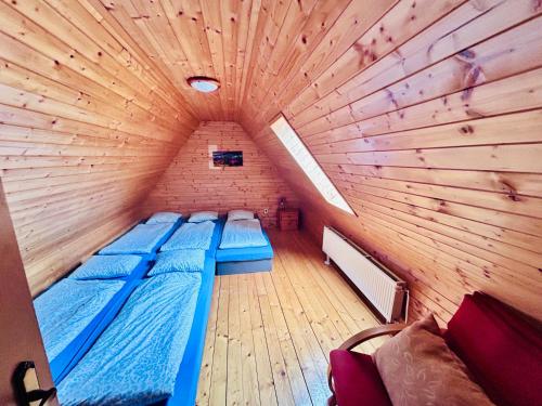 a small room with two beds in a wooden ceiling at Chatka pod orechom in Terchová