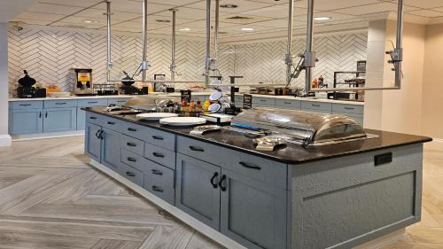 a large kitchen with blue cabinets and a large island at Staybridge Suites Pensacola Airport by IHG in Pensacola