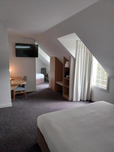 ein Hotelzimmer mit einem Bett und einem Fenster in der Unterkunft Kyriad Hotel Laval in Laval