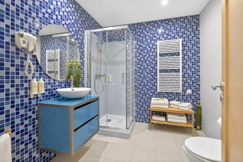 a blue tiled bathroom with a sink and a shower at Aquamar Pro 116 in Quarteira