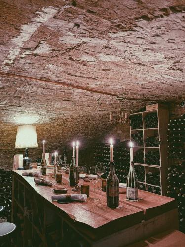 a table with bottles of wine and candles on it at La Chaumée par L'émulsion in Saint-Alban-de-Roche
