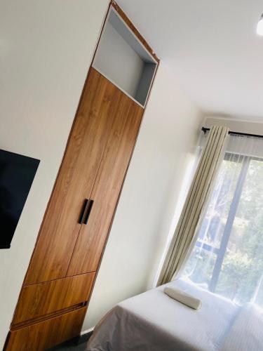 a wooden cabinet in a bedroom with a window at Haven stay in Kiambu