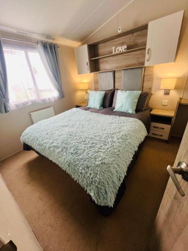 a bedroom with a large bed in a room at Calypso Hot Tub Breaks Tattershall Lakes Pet Friendly in Tattershall