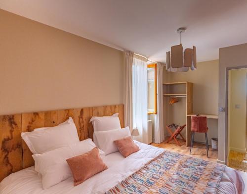 a bedroom with a bed with white sheets and pillows at Chambres D'hôtes Casa Della in Bassoues