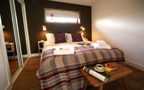 a bedroom with a bed with a table with towels on it at Jog Lodge 5 By Together Travel - 3 Bed in John O Groats