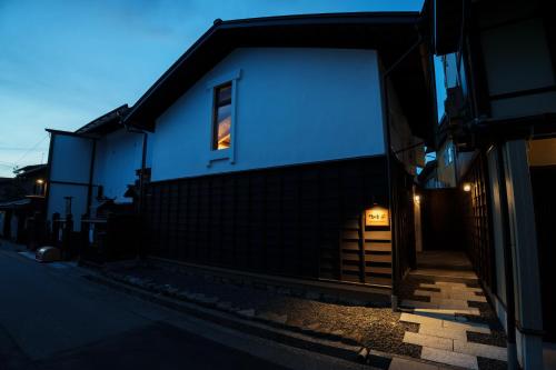 a white building with a window and a fence at NEKO no TSUKI in Takayama
