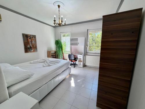 a bedroom with a bed and a desk and a chair at Dalyan Grand Garden in Ortaca