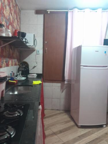 a kitchen with a refrigerator and a counter top at Hospedagem Mariano in Arraial do Cabo