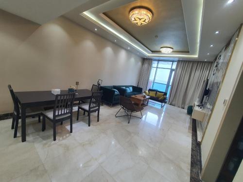 a living room with a table and a couch at Stylish 2 BR Apartment in Ajman Residences Tower 4 in Ajman 