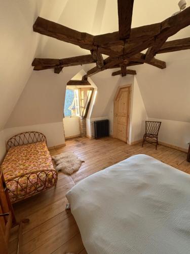 an attic bedroom with a bed and a chair at Castel de Grafeuille in Hautefage