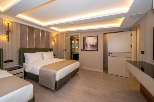 a hotel room with two beds and a television at Karaköy Prive Suites in Istanbul