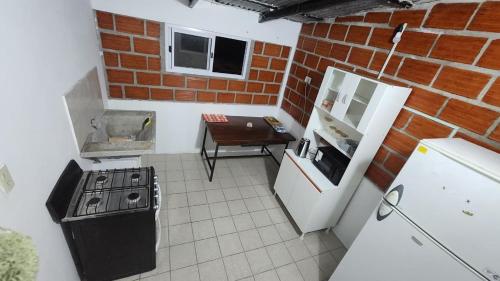 a kitchen with a stove and a brick wall at Norte Hogar in Salta