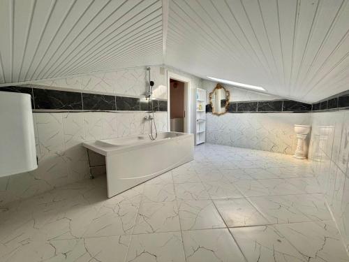 a white bathroom with a sink and a refrigerator at Dalyan Grand Garden in Ortaca