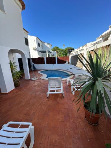 a patio with two chairs and a swimming pool at Villa Oleander in Vale do Lobo