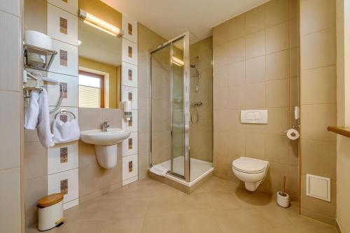a bathroom with a toilet and a shower and a sink at Hotel Aviator - kompleks Silesia Ring in Kamień Śląski
