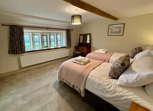 a bedroom with two beds and a window at Moorlands Farm Holidays in Keighley