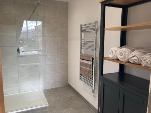 a bathroom with a shower with a glass door at Moorlands Farm Holidays in Keighley