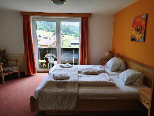 a bedroom with a large bed and a large window at Apartment House Seerose self check-in in Obertraun