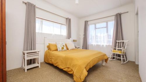 a bedroom with a bed and a large window at 206 On Main in Agulhas