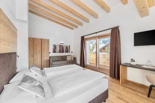 a bedroom with a large bed and a large window at Hotel Panorama in San Martino di Castrozza