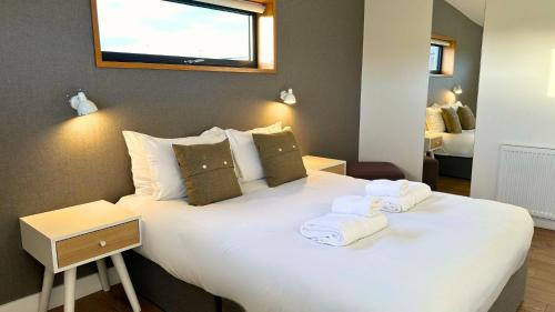 a bedroom with a white bed with towels on it at Jog Lodge 10 By Together Travel - 3 Bed in John O Groats