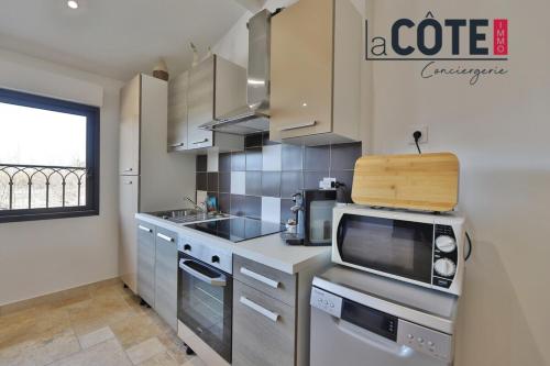 a kitchen with a microwave and a counter top at A La Vaquera - Gîte équestre in Châteauneuf-lès-Martigues