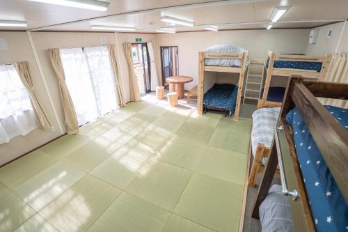 a room with several bunk beds and a room with at 皓雲庵plus in Miyakonojō