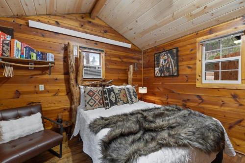 a bedroom with a bed in a log cabin at Raven Rock Getaway- Firepit Nights Getaway in Rapid City