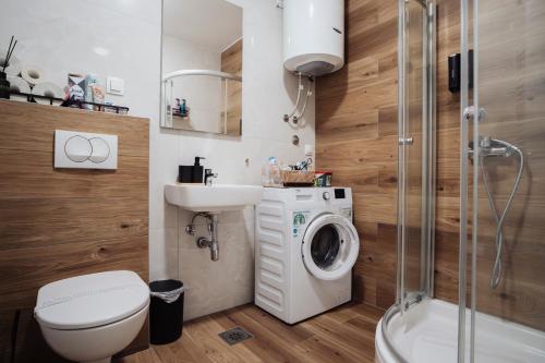 a bathroom with a toilet sink and a washing machine at Sky View - Apartment & GARAGE, Banja Luka in Banja Luka