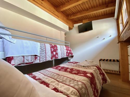 a bedroom with a bed in a room with wooden ceilings at Mansarda vista lago in Auronzo di Cadore