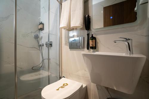 a bathroom with a shower and a toilet and a sink at Kucuk Velic Hotel in Gaziantep
