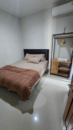 a bedroom with a bed and a mirror on the floor at Ndalem Livtuhayu in Godean