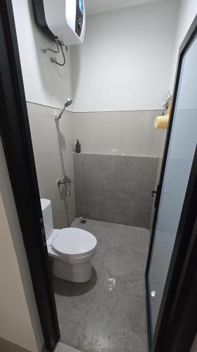 a small bathroom with a toilet and a shower at Ndalem Livtuhayu in Godean