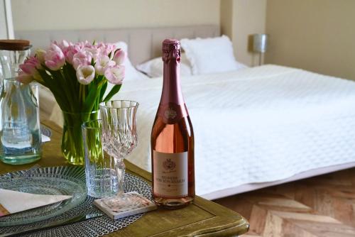 a bottle of wine sitting on a table next to a bed at Bohemian in Šamorín