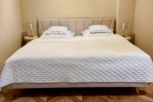 a bedroom with two beds with white blankets and pillows at Bohemian in Šamorín