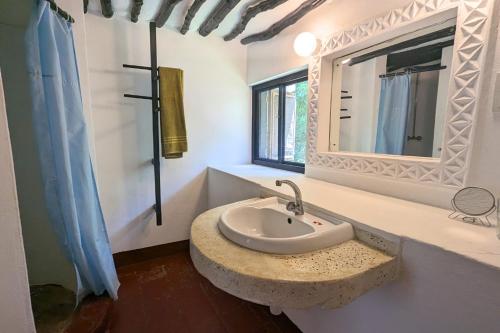 a bathroom with a sink and a mirror at Kusini Beach Cottages in Diani Beach