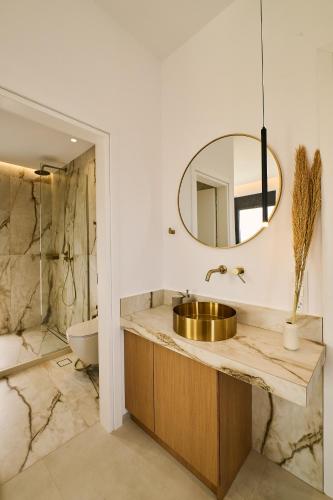 a bathroom with a sink and a mirror at POLYTELIA - Luxury Living in Elaía