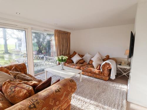 a living room with couches and a table at Three Ways in Diss