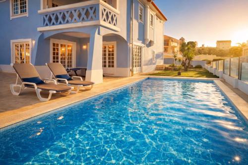 a swimming pool in the backyard of a house at Ericeira -Oceonview Villa with Pool and Whirlpool in Ericeira