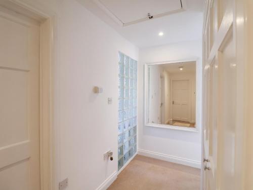 a bathroom with a mirror and a hallway at Three Ways in Diss