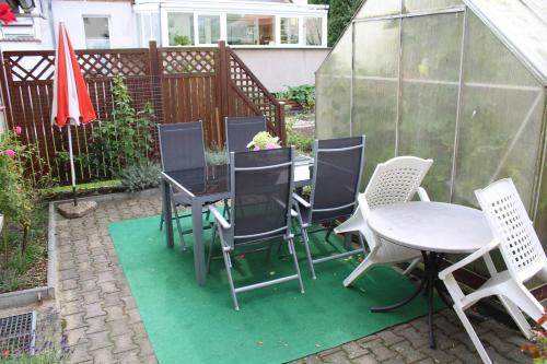 a patio with a table and chairs and a greenhouse at Bungalow Poggendorf in Eldena