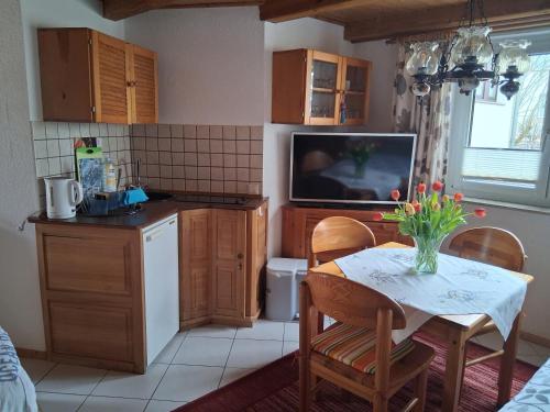 a kitchen with a table and a tv in a kitchen at Bungalow Poggendorf in Eldena