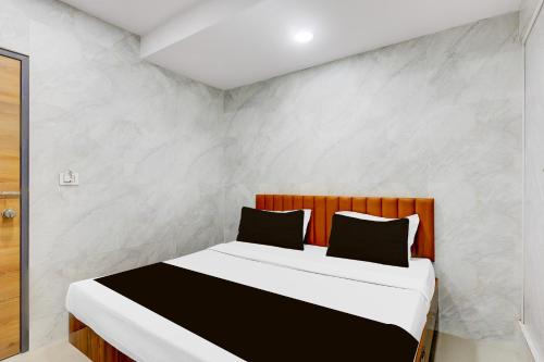 a bedroom with a bed in a room at Hotel O Lotus in Surat