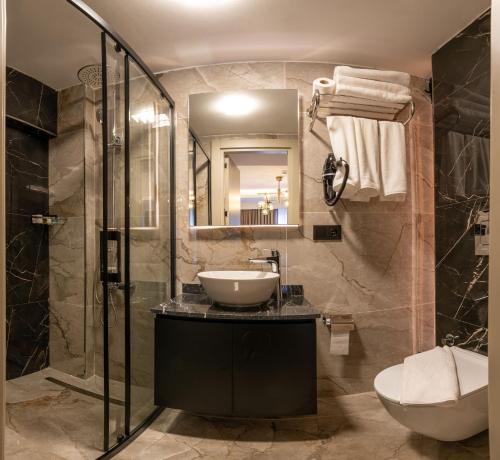a bathroom with a sink and a shower at Karaköy Prive Suites in Istanbul