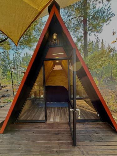 a tent with a bed inside of it at Cabina con terraza vista al río en Roca Truful in Melipeuco