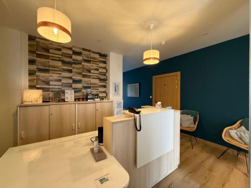 a kitchen with blue walls and a counter in a room at Hôtel La Porte Saint Pierre-Logis Hôtel Intra Muros RÉNOVÉ en 2026 in Saint Malo