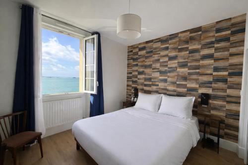 a bedroom with a large bed and a window at Hôtel La Porte Saint Pierre-Logis Hôtel Intra Muros RÉNOVÉ en 2026 in Saint Malo